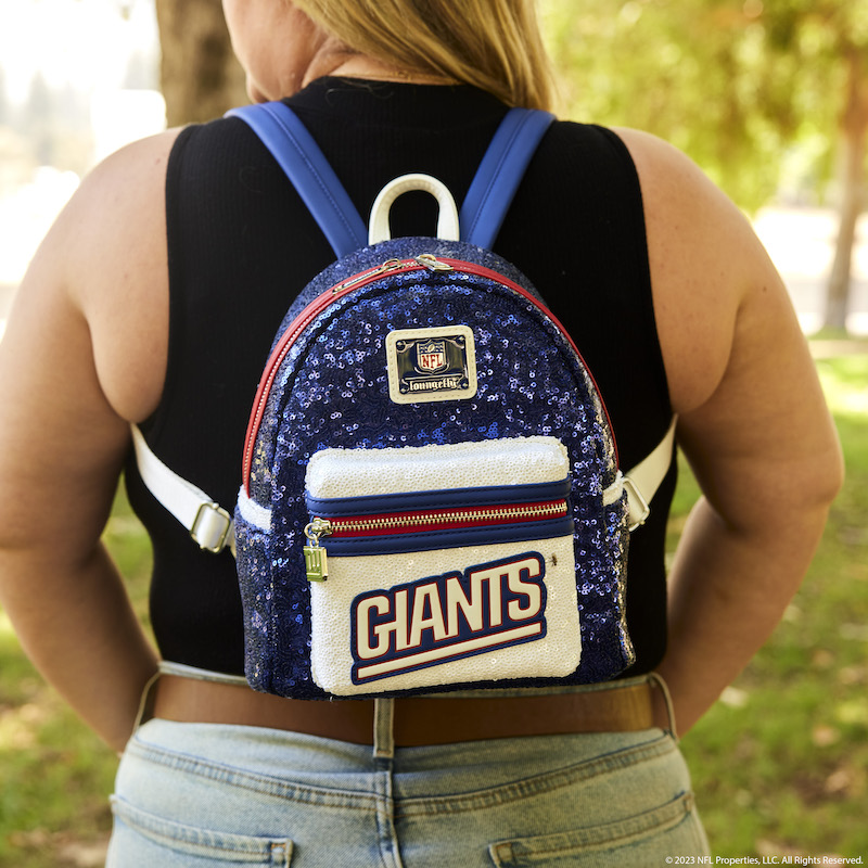 Woman in black shirt wearing the NFL New York Giants Sequin Mini Backpack outside in a park